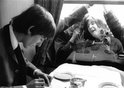 George Harrison on a train during the filming of a 'Hard Day's Night', with adoring fans outside looking through the window